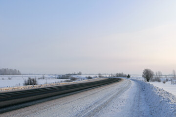 Road through snowy winter fields