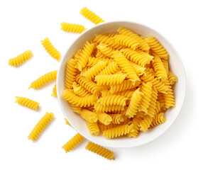 Raw spiral pasta in a plate on a white background, isolated. The view from top