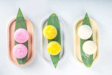 Traditional Japanese dessert mochi. Colorful mochi ice cream on a white table, whole and cut with berry, fruit filling