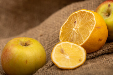 Obraz na płótnie Canvas Sliced lemon and fresh green apples on a homespun cloth with a rough texture.