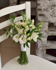 Beautiful bridal bouquet of white flowers and greenery, decorated with long silk ribbon.