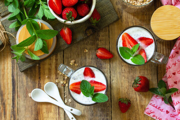 Healthy eating. Breakfast concept. Homemade granola with strawberry, yogurt, chia seeds and fresh berries on a rustic table. Top view flat lay.
