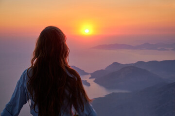 Fototapeta premium Beautiful girl bathes in the rays of the setting sun