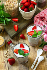 Healthy eating. Breakfast concept. Homemade granola with strawberry, yogurt, chia seeds and fresh berries on a rustic table.