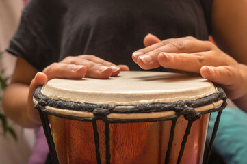 Closeup to woman's hands playing the drum. African djembe