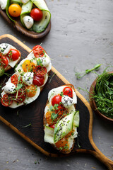 Toast with cherry tomatoes, mozzarella and microgreens. Light healthy breakfast. View from above.