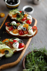 Toast with cherry tomatoes, mozzarella and microgreens. Light healthy breakfast. View from above.
