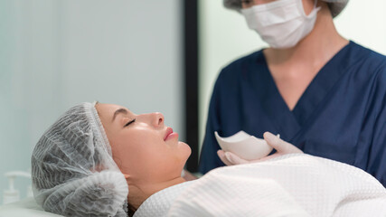 Obraz premium A beautician doing beauty treatment for young woman at clinic