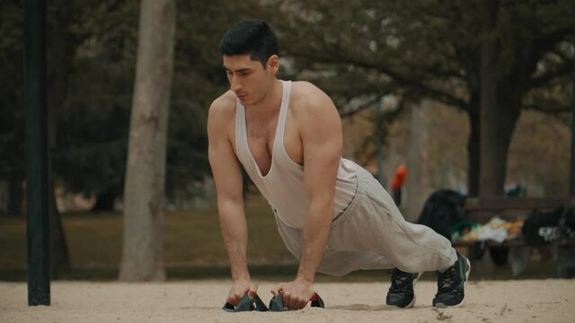 hombre haciendo flexiones  estilo diamante en el parque, hombre de pelo negro haciendo deporte al aire libre, hombre musculoso con camiseta blanca haciendo ejercicio en el parque