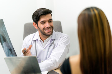 Male surgeon talking with female patient in clinic