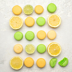 Lemon and lime French Macaroons with  fruit filling on a creamy white clay background, decorated with fresh limes and lemons