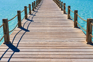 Fototapeta premium Cozy neat wooden bridge against the backdrop of beautiful sea water