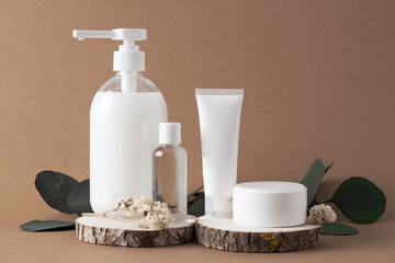 Cosmetic background with cosmetic skin care products and on dark brown. Flat lay, copy space