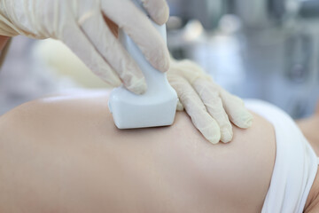 Doctor conducts ultrasound examination of mammary glands of woman
