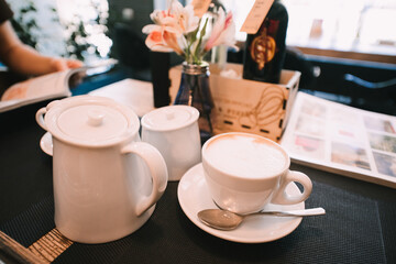 coffee in cups, latte, cappuccino, sugar bowl, table set for lunch in a cafe
