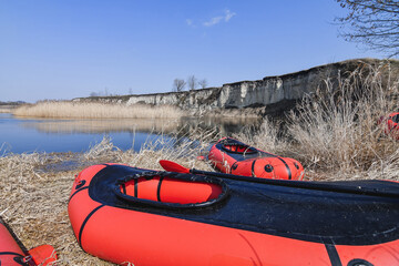 Red packraft rubber boats on the river bank. Selective focus. Active lifestile concept.