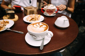 coffee in cups, latte, cappuccino, sugar bowl, table set for lunch in a cafe