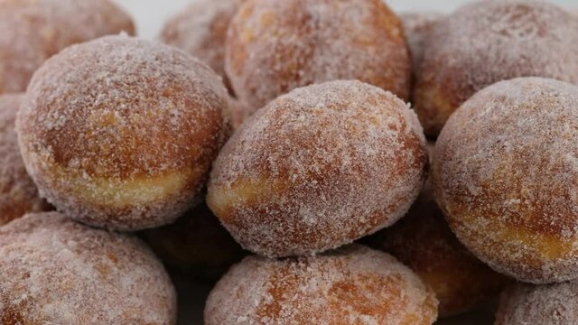 Berliners. Close-up camera movement. Sugar donuts are on a serving tray on a white plate. Delicious sweet donuts. Making donuts with jam.