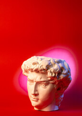 Plaster pot in the form of David's head on a red background.