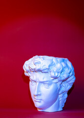 Plaster pot in the form of David's head on a red background.