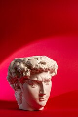 Plaster pot in the form of David's head on a red background.
