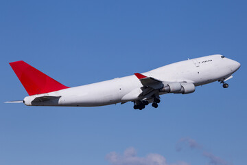 Widebody cargo aircraft departing with blue sky