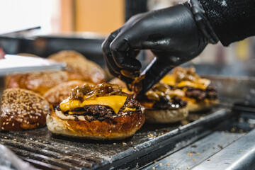 A hamburger with cheddar prepared for service on the grill