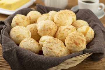 Typical brazilian cheese bun in a basket, coffee and butter
