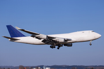 Widebody cargo aircraft landing with blue sky