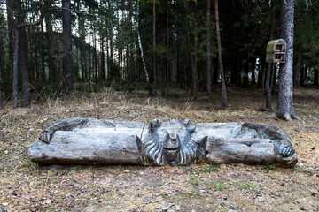 A wooden bench made from the trunk of a fallen tree in the shape of a Russian bear in the Vshivaya Gorka park in Kirzhach, Vladimir region.