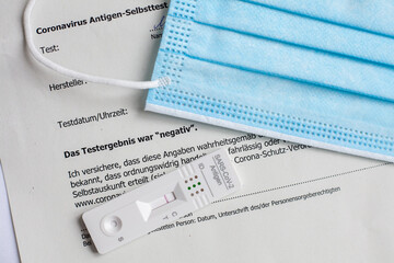 negative rapid antigen test SARS-CoV-2 , medical mask and document in german