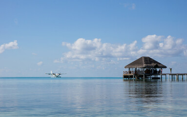 blue and yellow seaplane on the lagoon of a Maldivian resort on a sunny day. amazing travel concept