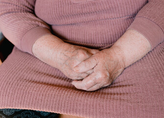 hands of an old woman with wrinkles and age spots close-up.