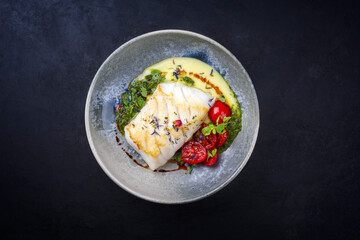 Modern style traditional fried skrei cod fish filet with mashed potato cream and coriander lime...