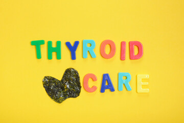 inscription thyroid care and thyroid from nori algae on yellow background