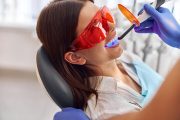 Teeth whitening for woman. Bleaching of the teeth at modern dentist clinic