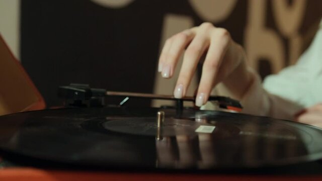 Hand adjusts the head old record player vinyl discs at home. vinyl audio player