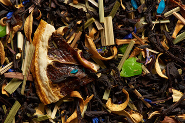 Mixed tea leaves with fruits as a background.
