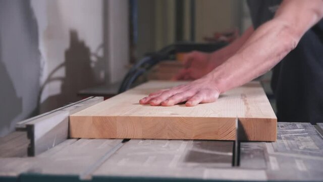 Worker using circular saw for cutting wooden board. Accuracy and concentration concept.