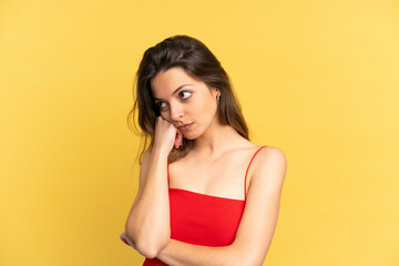 Young caucasian woman isolated on yellow background with tired and bored expression