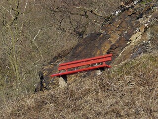 Rote Bank als Blickfang vor Schieferfelsen