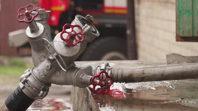 Fire hose with water at the site of a fire in a building in the city. Close-up. Fire extinguishing with water from a hydrant