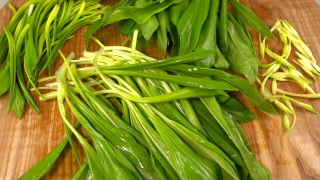 Wild garlic leaves on a wooden cutting board.