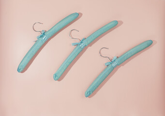 Soft green hangers for clothes on pink background.  Empty cloth hanger template. Fashion blog,  sales,  store, online  shopping concept. 