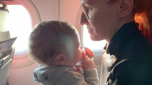 Woman and baby sit inside plane
