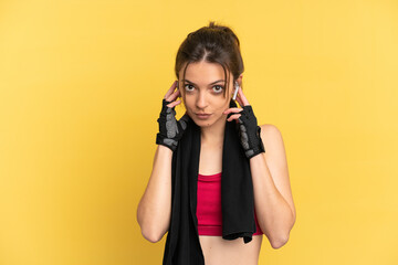 Young caucasian woman isolated on blue background listening music and looking to the front