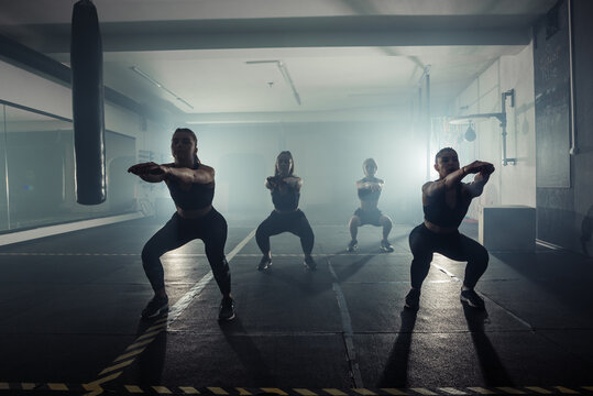 High contrast silhouette picture of  strong women working out indoors