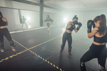 Boxer woman. Boxing fitness woman smiling happy wearing black boxing gloves. Portrait of sporty fit Asian model of boxing gym