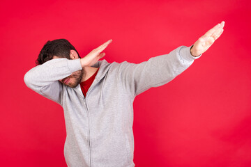 Photo of funky Young caucasian man wearing tracksuit over red background show disco move dab
