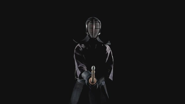 Japanese kendo fighter with with shinai on a black background